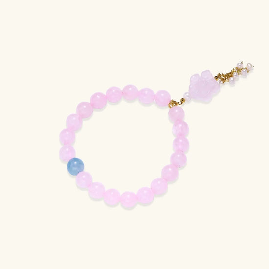 Stretchy beaded bracelet with pink rose quartz, blue aquamarine, carved floral pendant, and pearl tassel clasp.