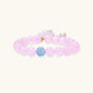 Stretchy beaded bracelet with pink rose quartz, blue aquamarine, carved floral pendant, and pearl tassel clasp.