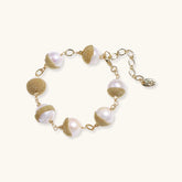 Adjustable bracelet with baroque pearls wrapped in delicate gold mesh netting connected by textured chain links