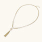 Long gold-plated necklace with freshwater pearls, chunky chain links, and flowing tassel pendant