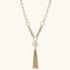 Long gold-plated necklace with freshwater pearls, chunky chain links, and flowing tassel pendant