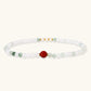Three layered white beaded bracelets with carved orange agate lotus centerpiece and freshwater pearls on cream background.